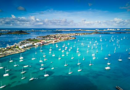 Stunning aerial view of Sint Maarten, blue waters peppered with sail boats. 