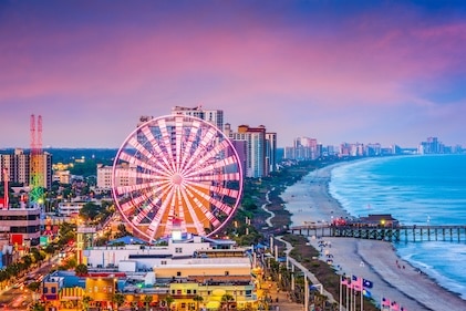 Drone image of Myrtle Beach Grand Strand and shoreline, under colorful sunset skies.