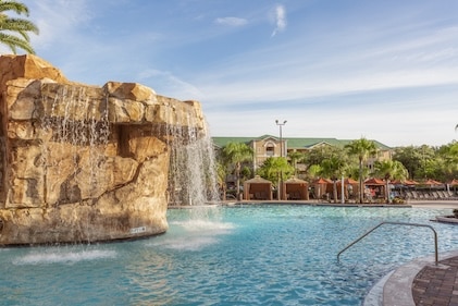Sparkling blue pool with rock formation and waterfall at Mystic Dunes, A Hilton Vacation Club in Orlando, Florida
