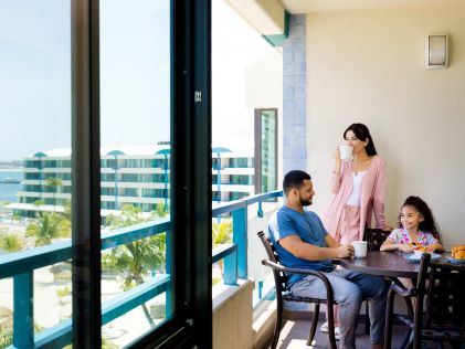 A family enjoys a meat in their Suite at Royal Palm, a Hilton Vacation Club in Netherland Antilles
