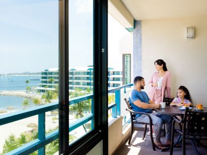 A family enjoying a meal in a Suite of Royal Palm, a Hilton Vacation Club