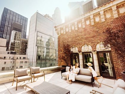 A mother and two kids on a rooftop lounge in New York City