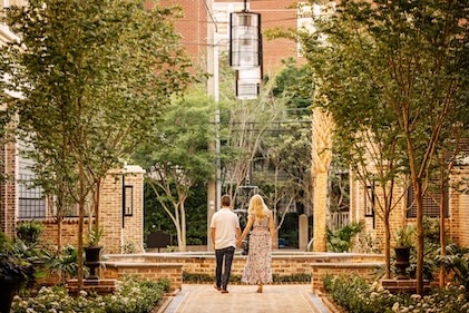 Image of a couple strolling through the courtyard at Liberty Place Charleston, a Hilton Club.