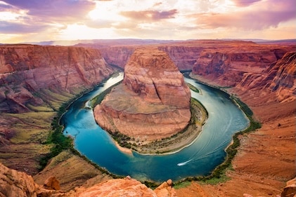 The deep blue path of the Colorado River traces a horseshoe path, winding around red rock in the Arizona Grand Canyon.