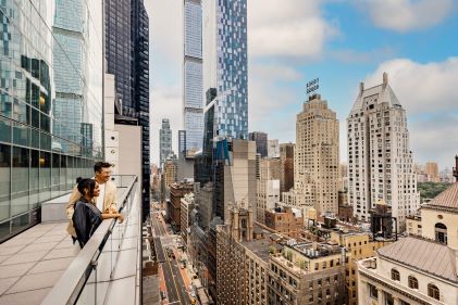 Couple overlooking NYC cityscape from West 57th Street, a Hilton Club, New York, New York.
