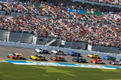 Aerial image, NASCAR race, cars-lined track, fan-filled stadium, HGV Ultimate Access. 