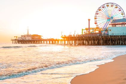 Idyllic beach scene, golden sands, blue skies, bright sun, crashing waves, Santa Monica Pier, Los Angeles, California. 