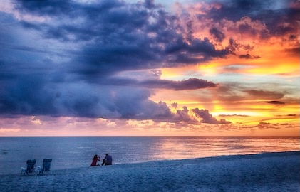 Sanibel Island beach with view of sunset in the distance over the open waters.