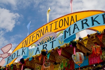 Closeup image looking up at the colorful International Folk Art Market sign and decorations in Santa Fe, New Mexico.