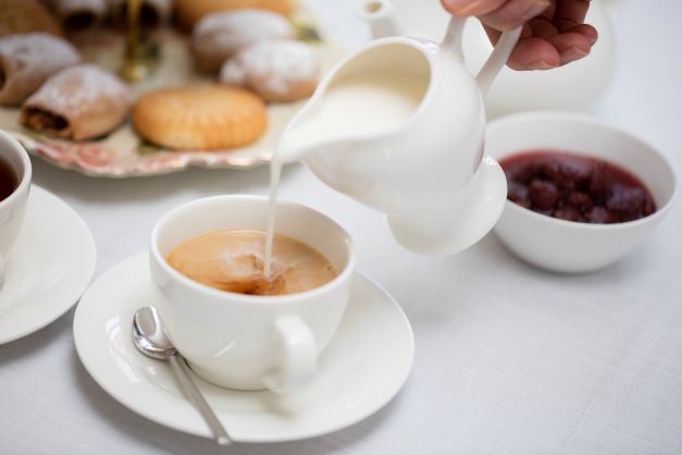 Close up, pouring tea, snacks in background, afternoon tea.