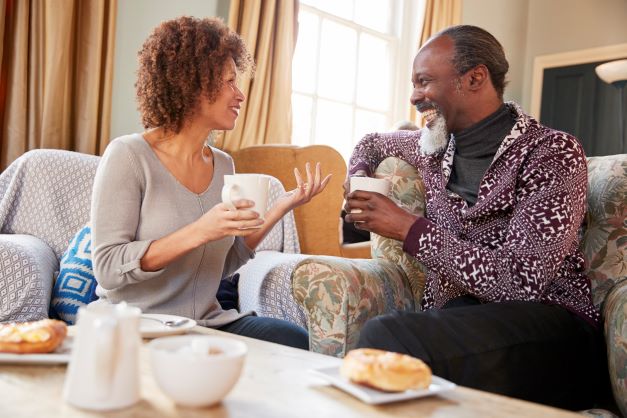 Couple talking, smiling, taking tea together.