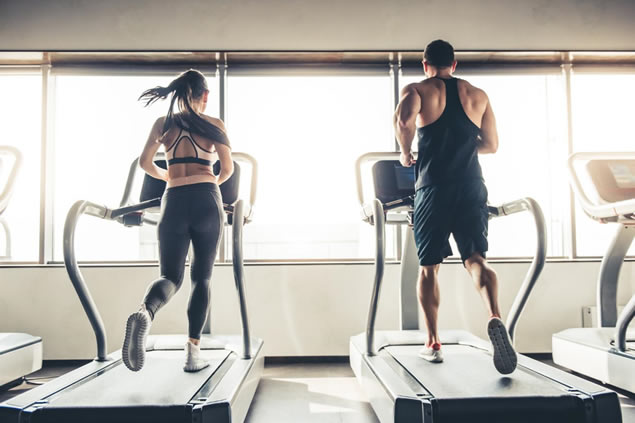 man and women running on treadmill