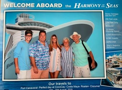 A family smiles for a picture while on a cruise
