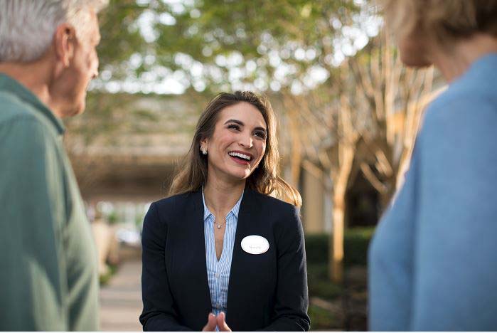 Smiling Hilton Grand Vacations Team Member talking with Owners. 