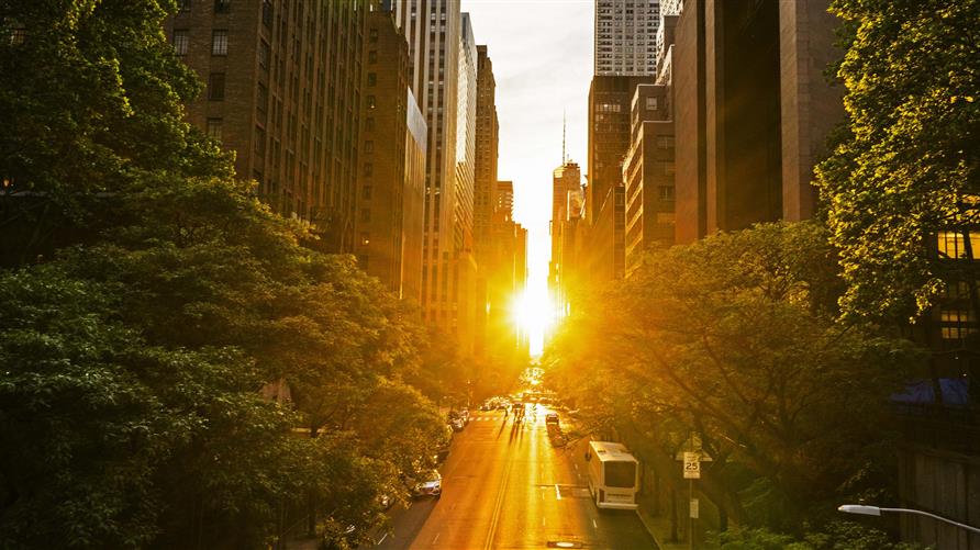 Sunrise over a New York City street between the buildings. 