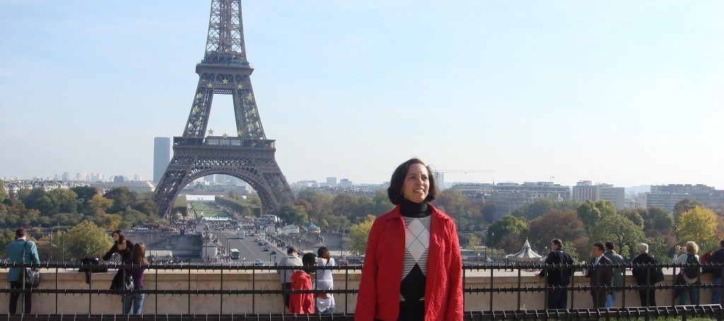 Hilton Grand Vacations Owner smiling and posing in front of the Eiffel Tower in Paris, France. 
