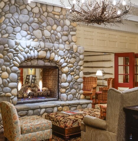 Armchairs sit in front of a stone fireplace in the lobby of Blue Mountain, a Hilton Grand Vacations Club.