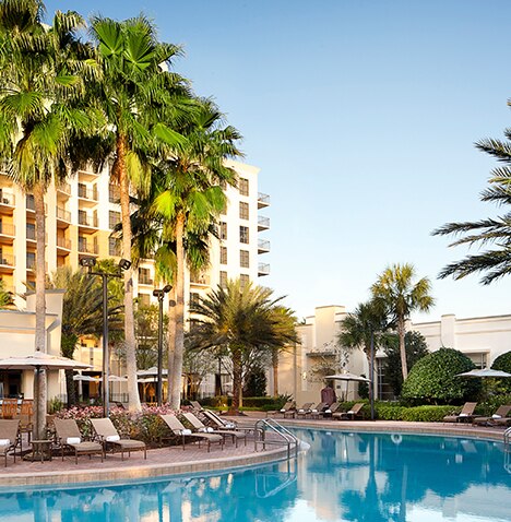 Pool, palm trees and lounge chairs at Las Palmeras, a Hilton Grand Vacations Club in Orlando, Florida.