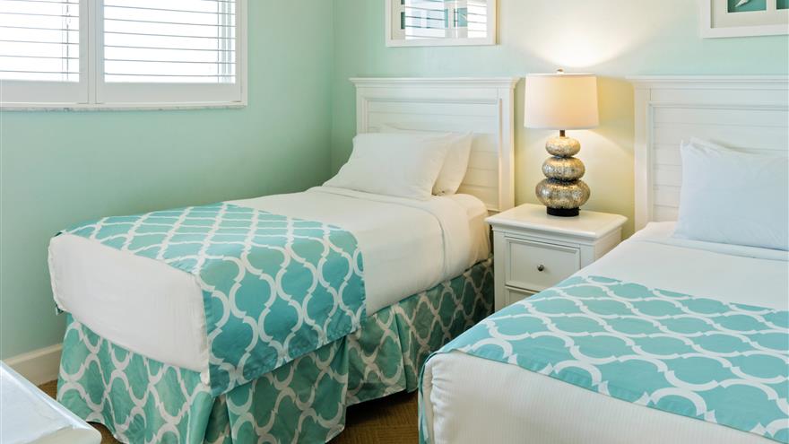 Two beds in a bedroom at The Charter Club of Marco Beach located in Florida.