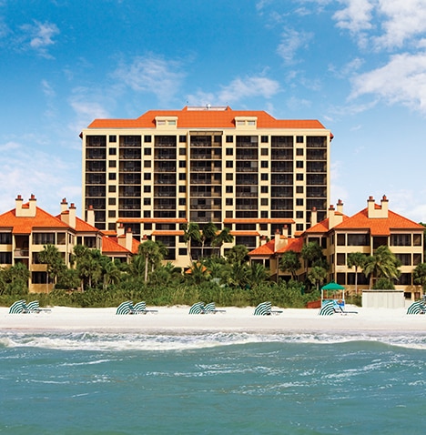View of the beach and exterior of Eagle Nest Beach Resort located at Marco Island, Florida.