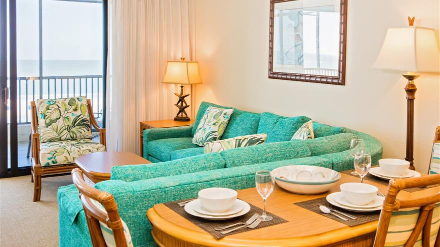 Dining area and living area with a view of the water at Seawatch On-the-Beach Resort located at Fort Myers Beach, Florida.
