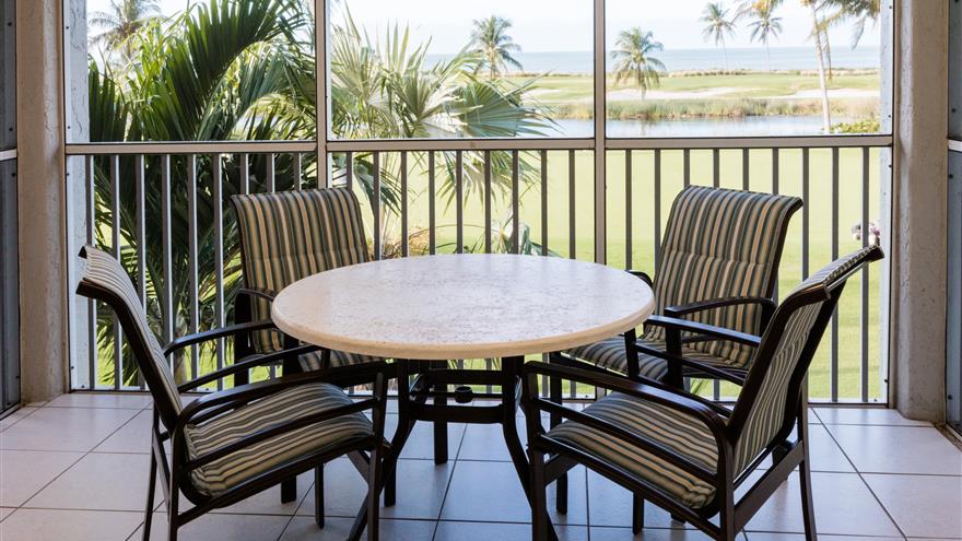 Dining area in an enclosed patio with a view of the gulf.