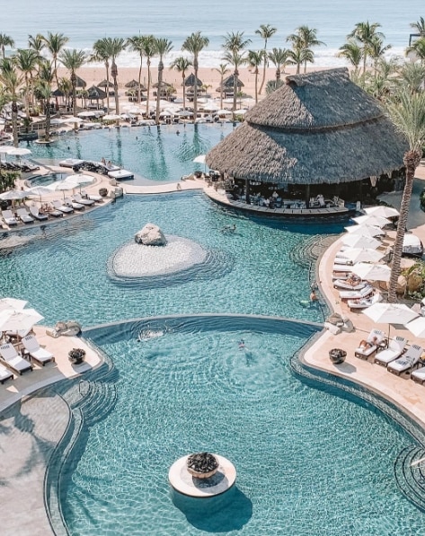 Aerial view of a palm tree lined pool and cabana at Cabo Azul, a Hilton Vacation Club.