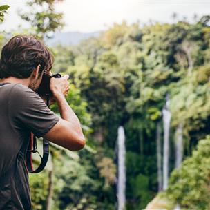 Man taking photos of Hawaiian forest