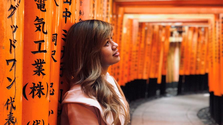 A woman gazing at an artistic hallway in Japan.