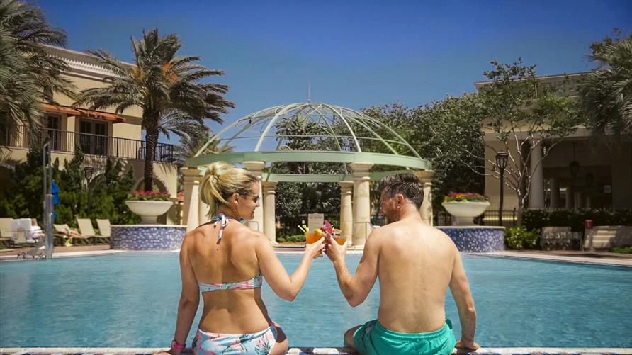 A couple poolside at Hilton Grand Vacations Tuscany Village in Orlando, Florida.