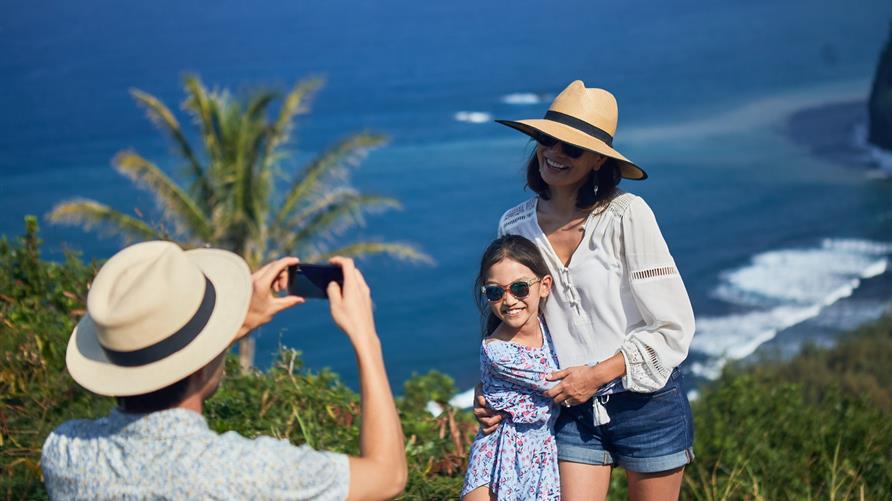 Family taking a picture while on vacation in an island paradise.
