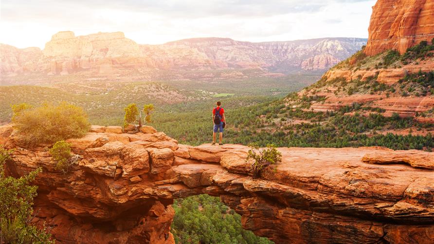 GettyImages-885620720 a man standing in front of a canyon